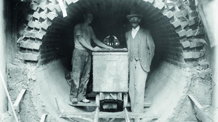 Black and white photo of 2 gentlemen in a stormwater drain 
